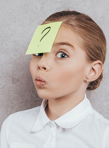 Mädchen mit Klebezettel an der Stirn, auf dem ein großes Fragezeichen steht