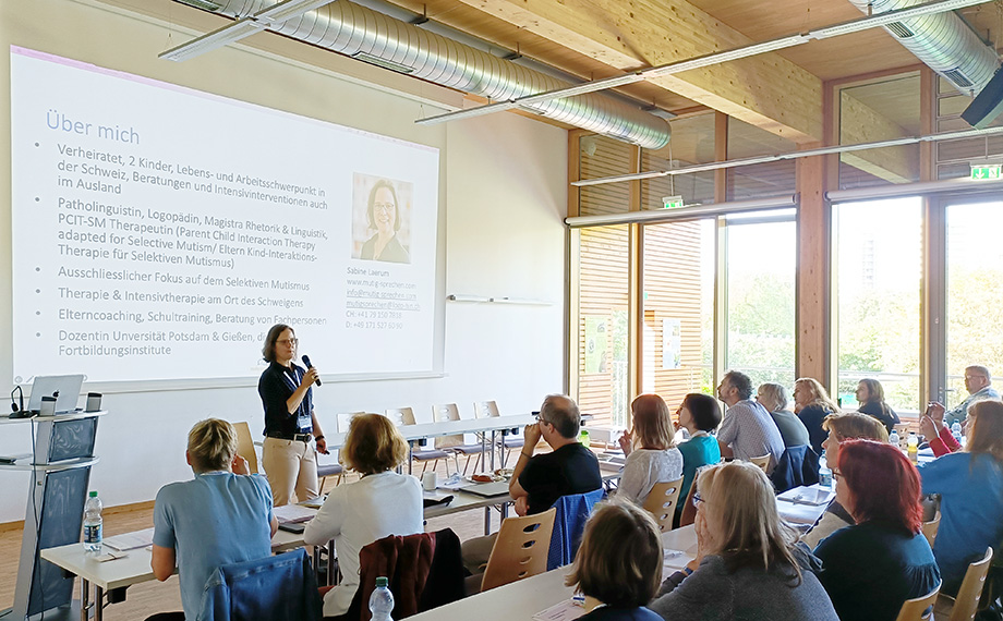 Die Referentin Sabine Laerum steht vor der Leinwand Präsentation Ihres Vortrages.