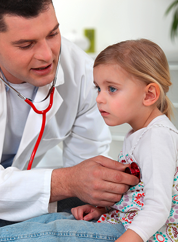 kleines Mädchen wird von einem Arzt mit einem Stethoskop untersucht