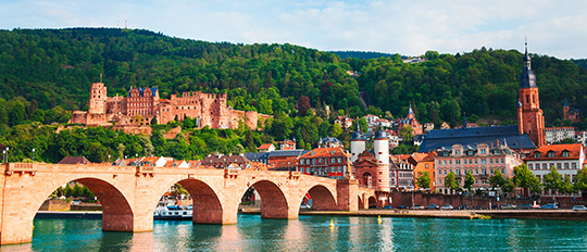 Auf dem Foto ist die Stadt Heidelberg mit Brücke, Burg und Kirche zu sehen