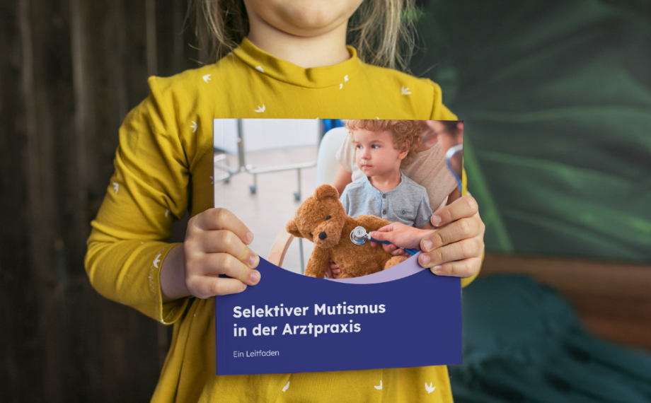 Ein kleines Mädchen zeigt den Leitfaden Selektiver Mutismus in der Arztpraxis.